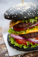 Close-up of black double beef burger, shallow depth of field, vertical shot