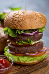 Double beef burger on a white sesame bun, close-up with shallow depth of field, selective focus