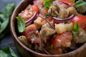 Close-up of salad with baked eggplants, fresh tomatoes and mint, selective focus