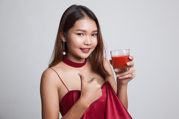 Young Asian woman thumbs up with tomato juice.