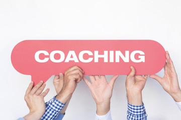 Group of people holding the COACHING written speech bubble