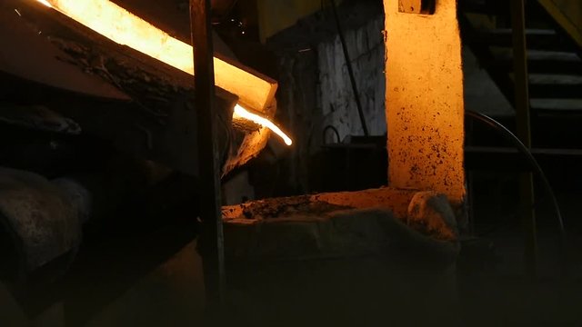 Metal Stream Flows Slowly with Sparks Puffs into Tank