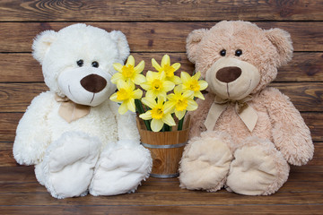 Two teddy bears with a bouquet