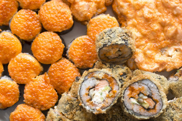 Sushi rolls with salmon, black caviar and sesame close-up macro shot