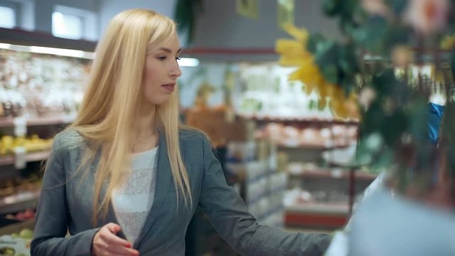 Blonde woman holding product in supermarket