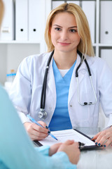 Doctor and  patient  discussing something while sitting at the table . Medicine and health care concept