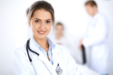 Fototapeta premium Female doctor smiling on the background with patient in the bed