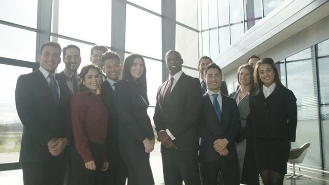  Portrait smiling diverse business group in large modern office building