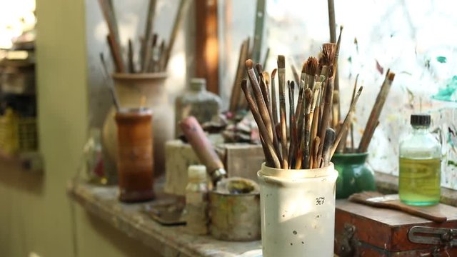 Stidio. Oil Painting Brushes. Various dirty paint brushes in a jar