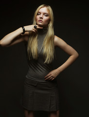 Portrait of beautiful young blonde girl in black dress. 