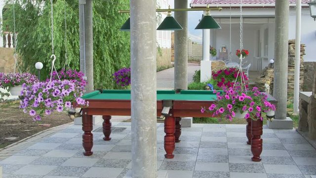 Outdoor billiard table area at back garden of a house. Two storey home with swimming pool and patio.