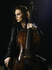 Photo of a beautiful woman posing with her old cello.