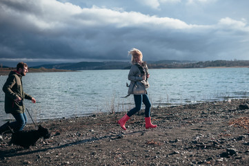 Family walks with a dog in the forest near a river in the rain