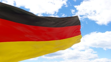 Waving flag of Germany on a blue cloudy sky.