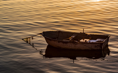 Barca con reflejos de los primeros rayos del sol en un amanecer placido