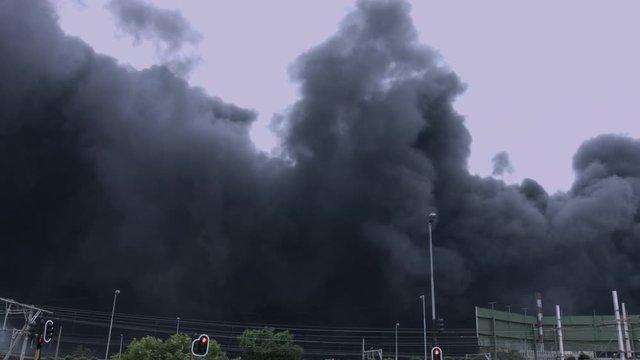 Toxic Smoke Engulfs City: Red Traffic Lights Amidst Industrial Explosion's Billowing Black Clouds