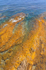 Colorful natural texture with blue sea and yellow rocks