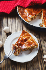 Hearty and delicious dinner, yeast dough cake with chicken, mushrooms, onions and spices on a dark rustic wooden background  