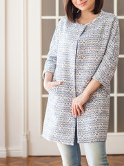 Woman dressed in autumn coat. Blue jeans. Studio