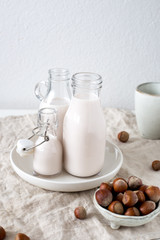 Vegan milk from nuts in glass jar. Hazelnut vegetarian drink on white rustic background