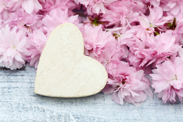Obraz na płótnie Canvas cherry flowers with white heart on wood