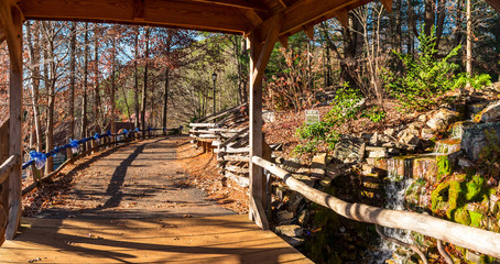 Fototapeta premium Little waterfall, bridge over the creek and footpath, Helen, USA.