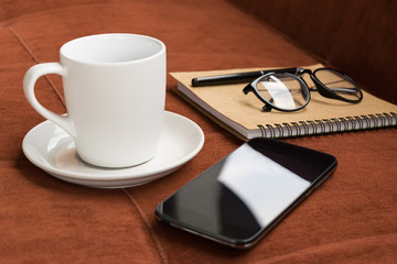 Cup,cup of coffee and smartphone with diary note on red carpet o