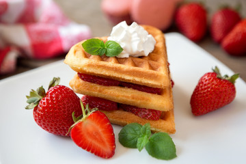 Stack of delicious freshly baked waffles with strawberries.