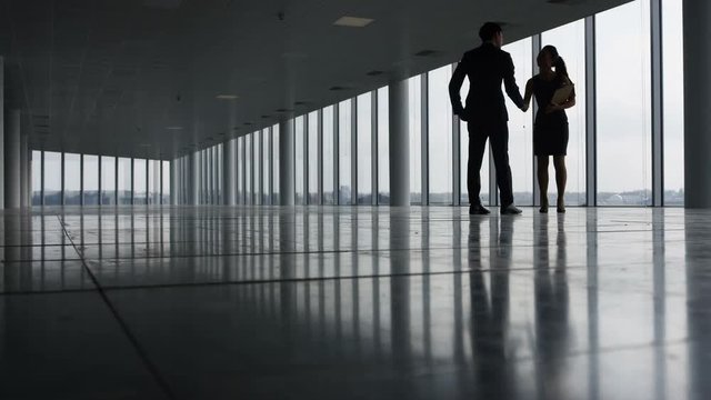  Business manager viewing empty commercial property with real estate agent