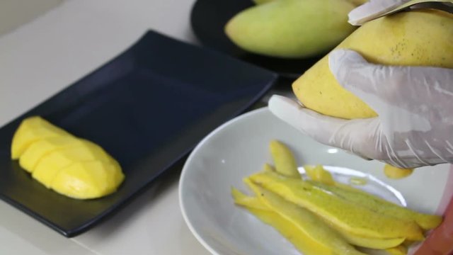 Hands cutting mango with knife