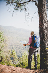 Young hipster hiking in in the mountains.