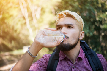 Obraz premium Men drinking water in the forest.