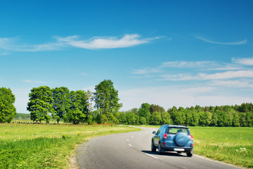 Obraz na płótnie Canvas Car on asphalt road in beautiful spring day at countryside