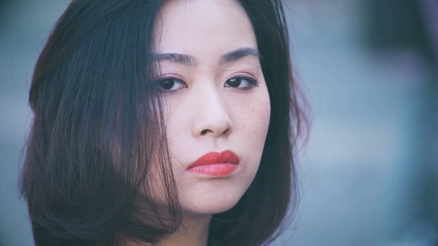 depressed and serious chinese woman in the city: Closeup Portrait