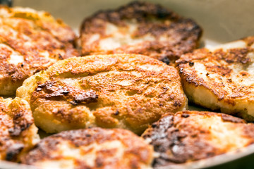 Golden pancakes in a frying pan. Cottage cheese fritters