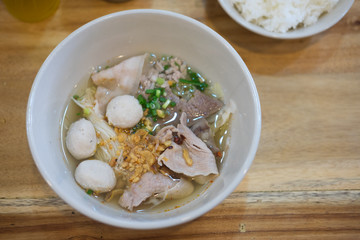 Noodle with pork ball and vegetables on wood table