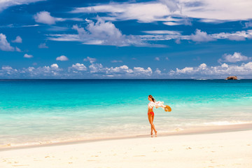 Fototapeta na wymiar Woman with sarong on beach at Seychelles
