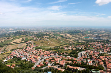 Obraz premium San Marino. Emilia-romagna. View on town with red roofs on blue sky background, horizontal view.