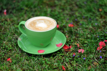 Green coffee cup on grass