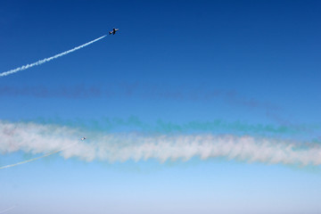 White line of track of airplane on blue sky background, horizontal view.