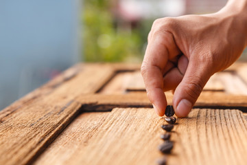 Man sorting coffee beans on vintage wooden table.