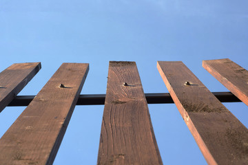 Wooden plank fence on blue sky background