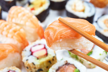 Sushi set. Chopsticks with portion of sushi