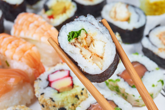 Sushi set. Chopsticks with portion of sushi