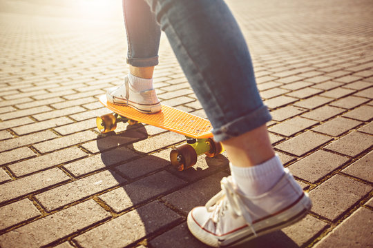 Hipster girl with skateboard outdoors. Closeup skateboarding. Active sporty woman having fun in park