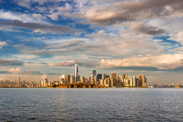New York Harbor view of Lower Manhattan Financial District skyscrapers and Ellis Island. The...