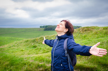 Successful Young Woman Hiker with Open Arms on the Top of a Mountain 
