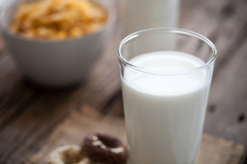 milk, cookies and bowl of cereal on wooden background