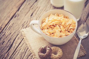 milk, cookies and bowl of cereal on wooden background