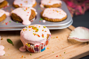 Cupcake with pink glaze on the wooden background. Selective focus.